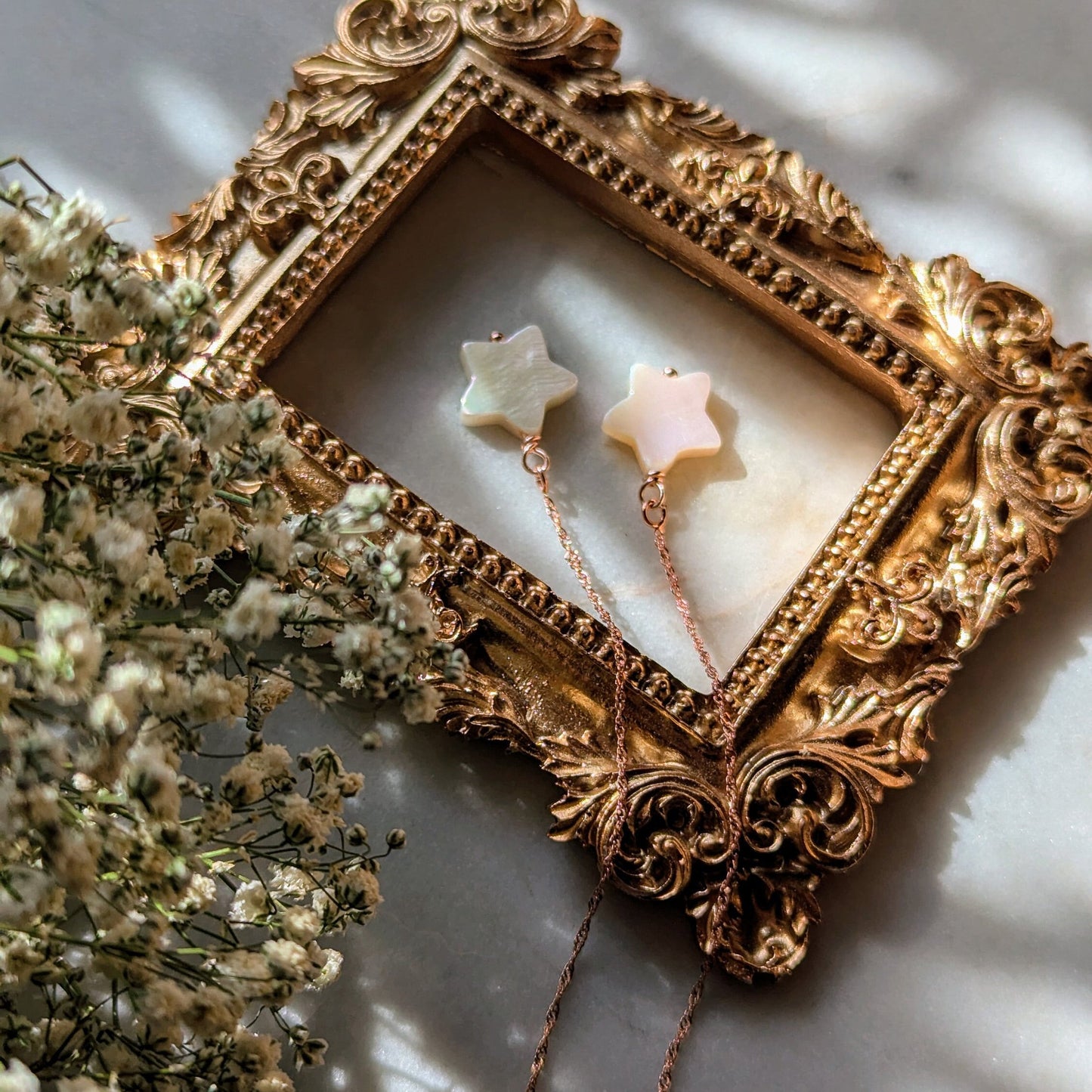 Boucles d'oreilles en fil d'or rose avec étoiles en nacre