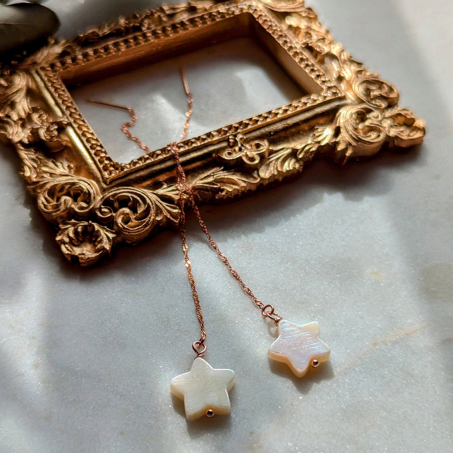Boucles d'oreilles en fil d'or rose avec étoiles en nacre