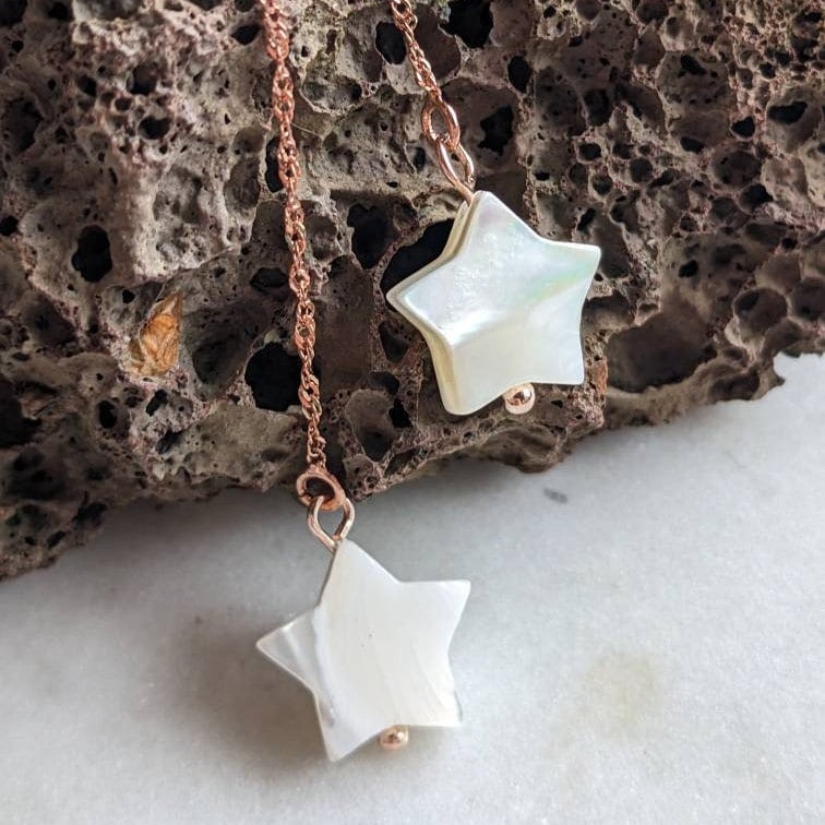 Boucles d'oreilles en fil d'or rose avec étoiles en nacre