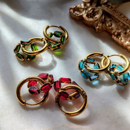 Golden stainless steel hoop earrings with loop made of cut glass beads with gold rim