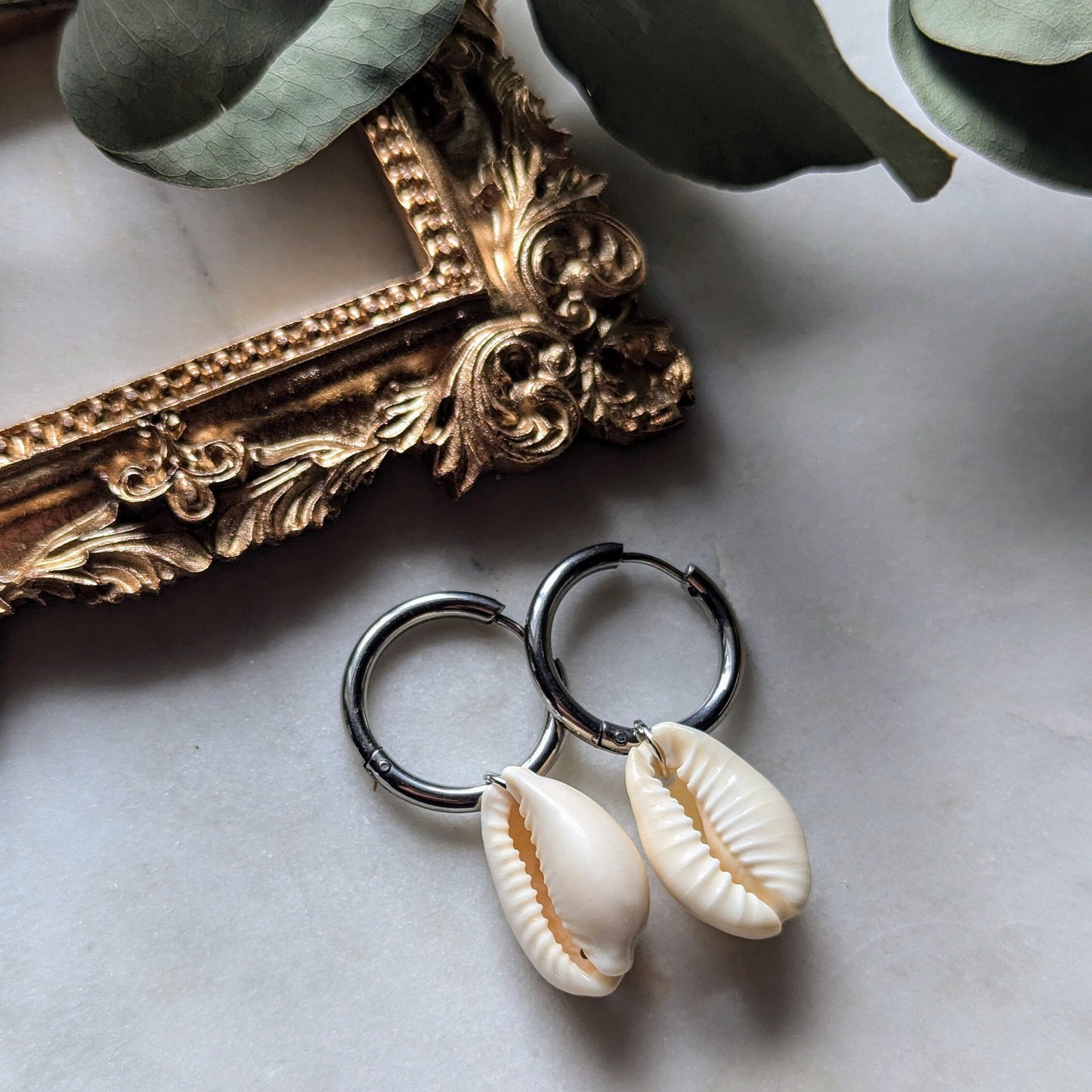 Stainless steel hoop earrings with cowrie shells