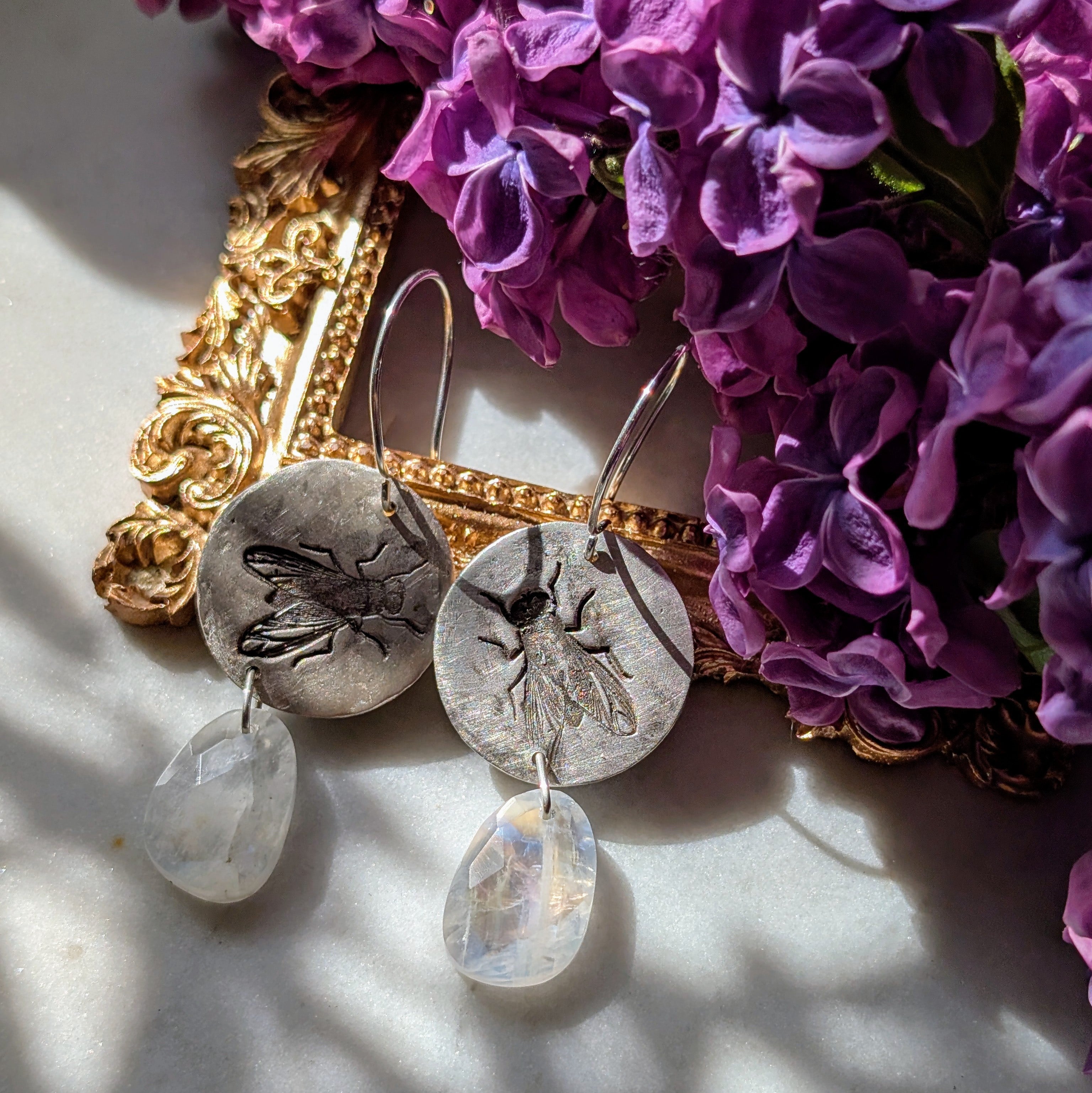 Handgefertigte Ohrringe aus Silber mit feinem Insektenrelief und Mondstein