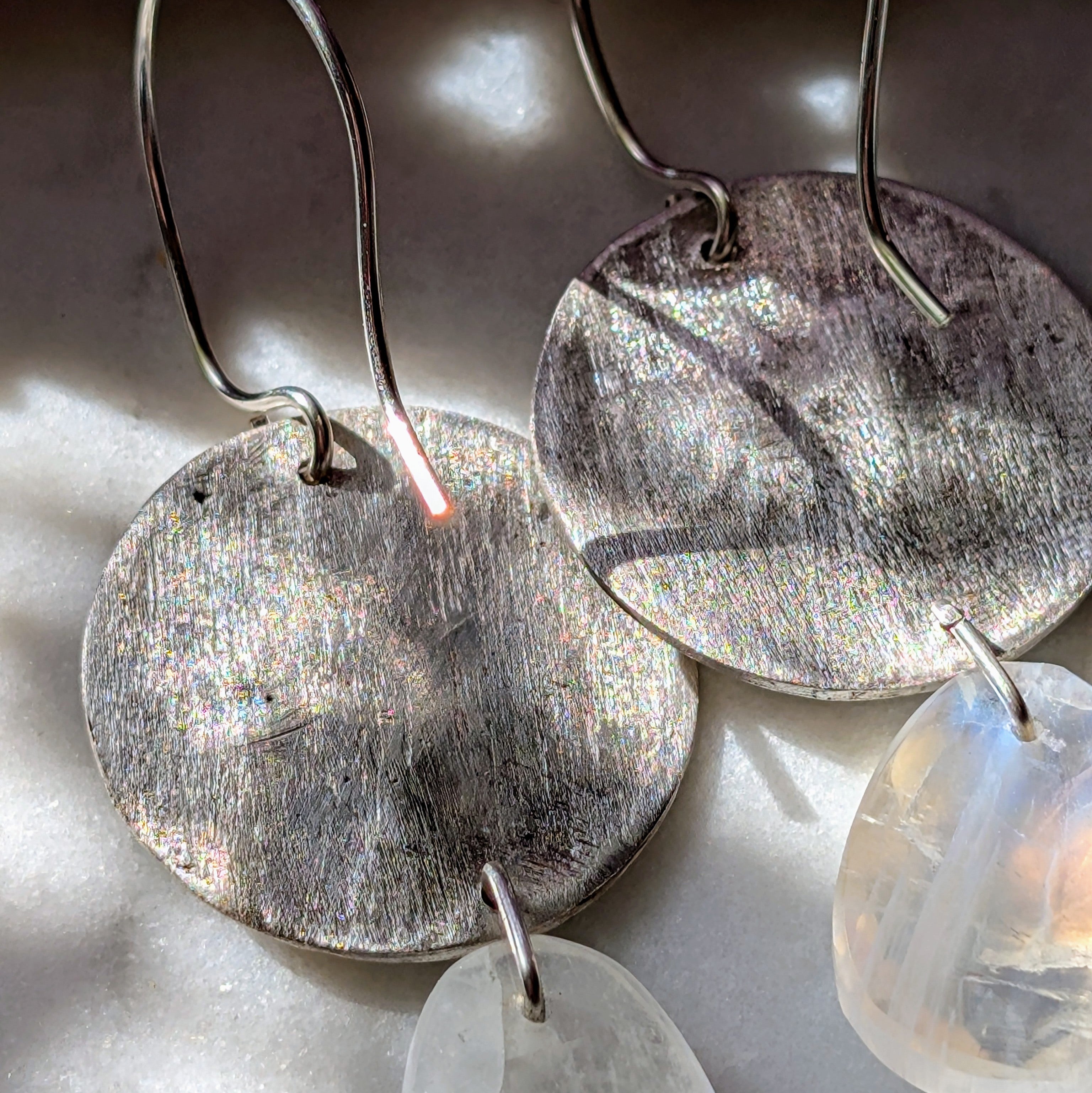 Handgefertigte Ohrringe aus Silber mit feinem Insektenrelief und Mondstein