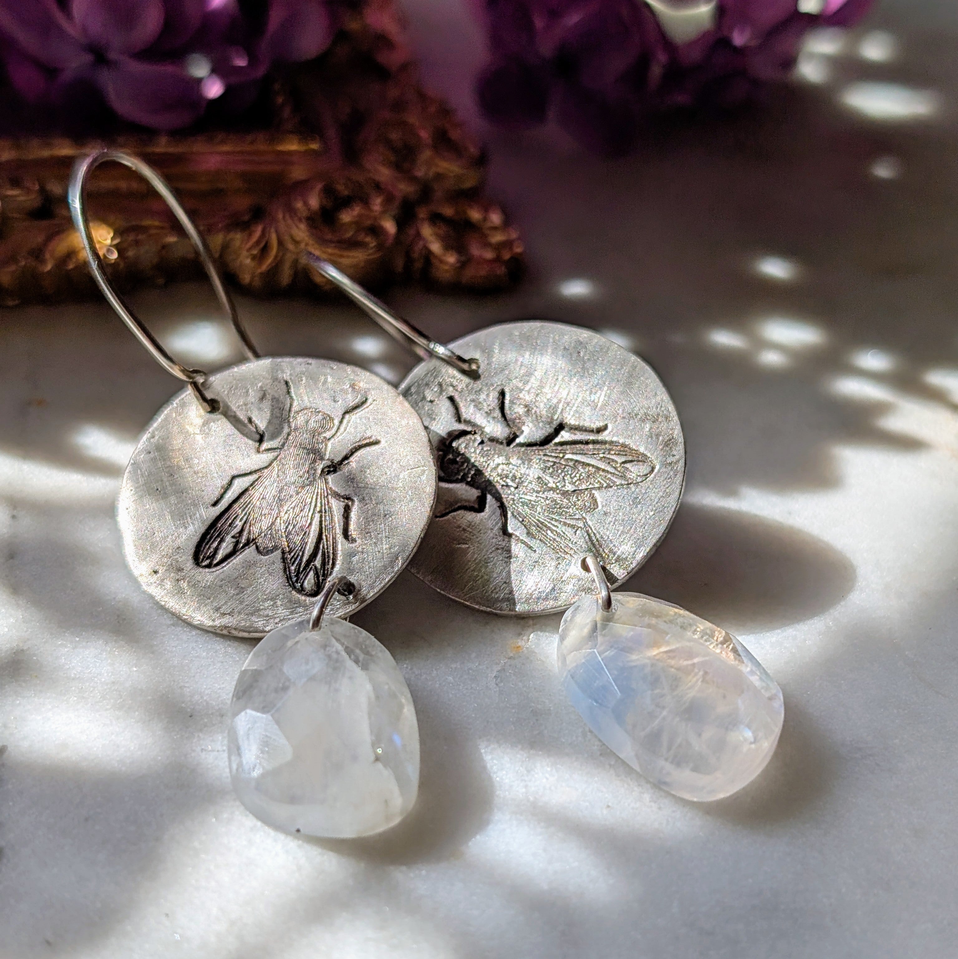 Handgefertigte Ohrringe aus Silber mit feinem Insektenrelief und Mondstein