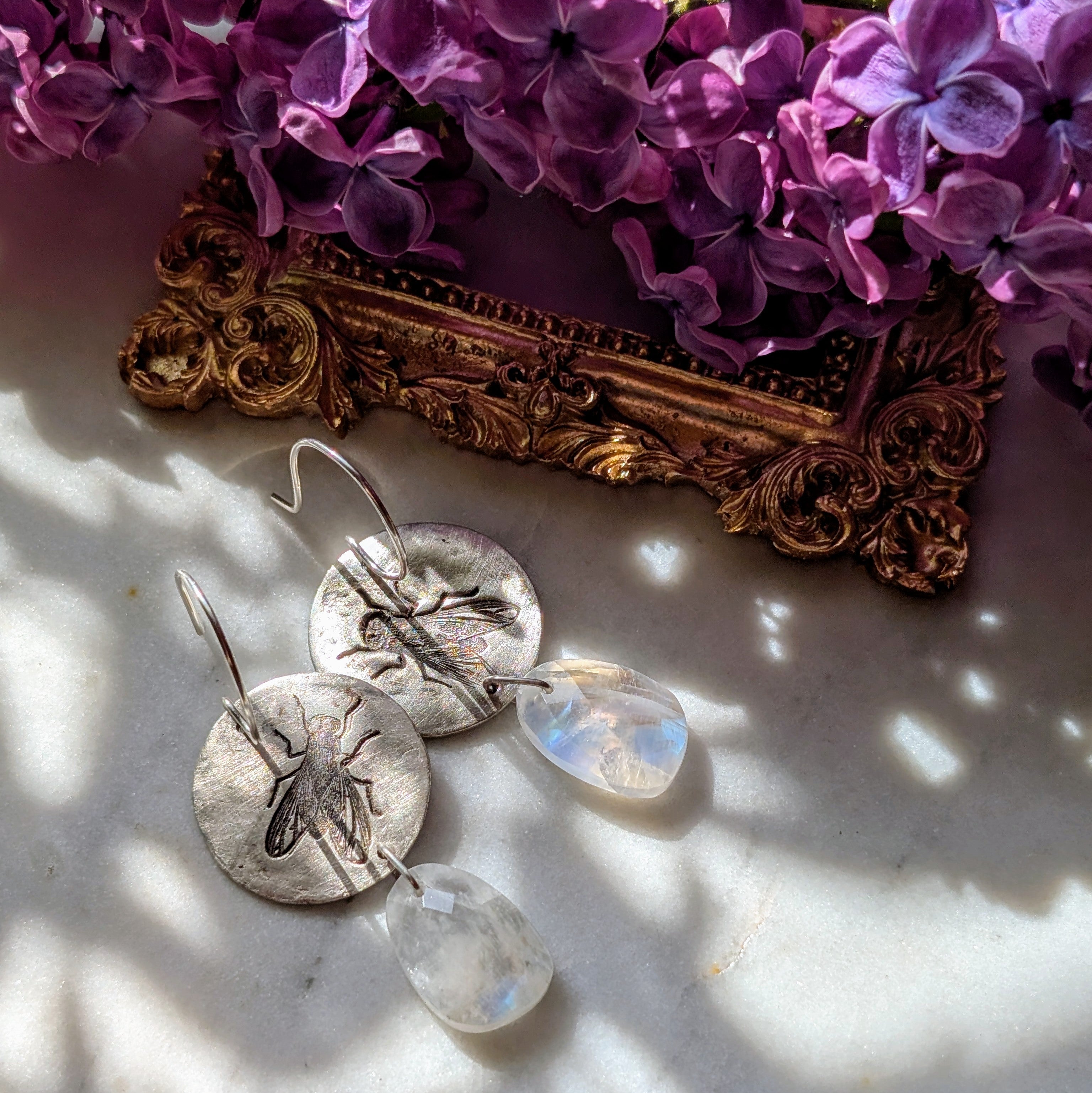Handgefertigte Ohrringe aus Silber mit feinem Insektenrelief und Mondstein